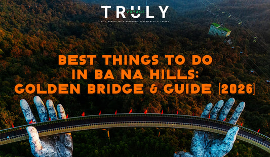 Truly Voyage blog post graphic titled "BEST THINGS TO DO IN BA NA HILLS: GOLDEN BRIDGE & GUIDE [2026]" showing an aerial view of the Golden Bridge supported by giant stone hands above lush forest mountains.