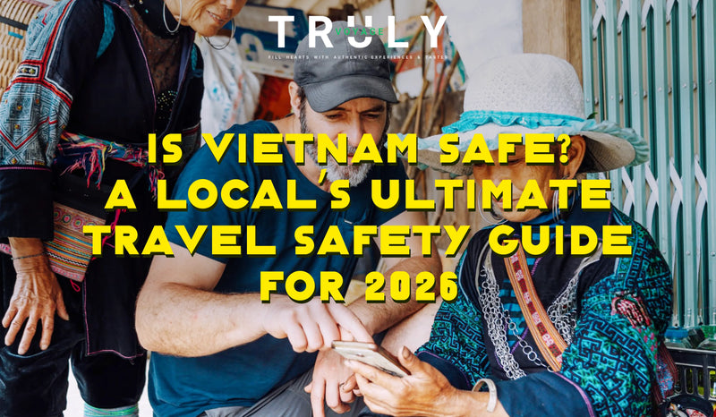 Truly Voyage blog post graphic titled "Is Vietnam Safe? A Local's Ultimate Travel Safety Guide for 2026" featuring a male traveler showing his smartphone screen to local ethnic minority women in traditional dress.