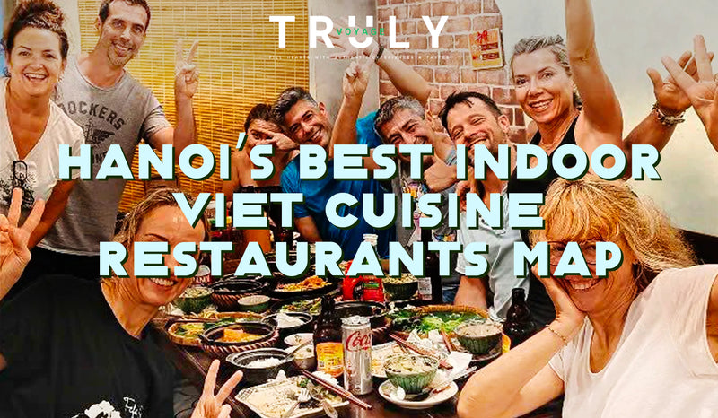 Truly Voyage blog post graphic titled "Hanoi's Best Indoor Viet Cuisine Restaurants Map" showing a group of happy tourists sharing a traditional Vietnamese meal at an indoor restaurant in Hanoi.